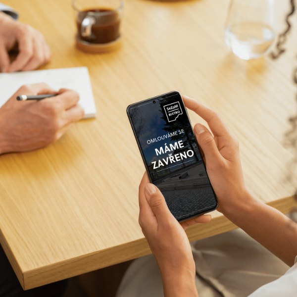 osoba ddrží v ruce mobil s obrazovkou Sezam bistra